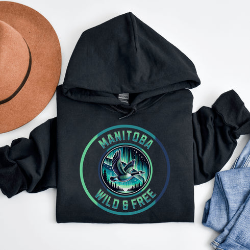 Embrace the spirit of the prairies with our Manitoba – Wild & Free hoodie, featuring a stunning graphic of a Canadian goose in flight beneath the mesmerizing northern lights.