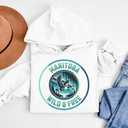 Embrace the spirit of the prairies with our Manitoba – Wild & Free hoodie, featuring a stunning graphic of a Canadian goose in flight beneath the mesmerizing northern lights.