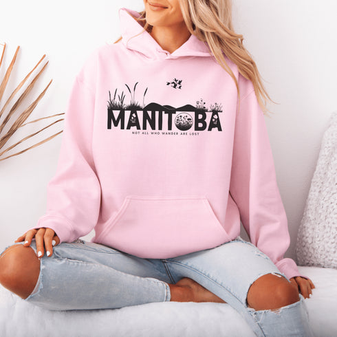 Featuring a prairie landscape, the design showcases wildflowers and prairie grasses blooming from the letters "Manitoba," artfully integrated into the scene.