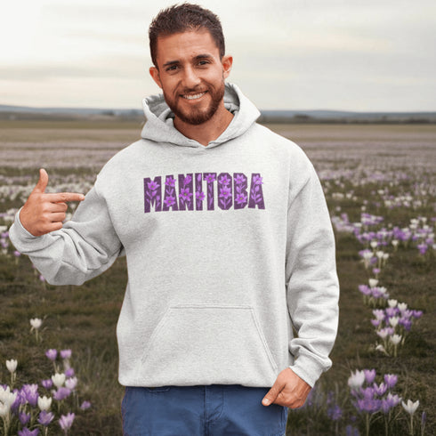 Celebrate the beauty of the prairies with our Manitoba Hoodie, featuring bold lettering filled with delicate purple prairie crocus flowers.