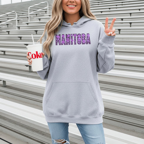 Celebrate the beauty of the prairies with our Manitoba Hoodie, featuring bold lettering filled with delicate purple prairie crocus flowers.