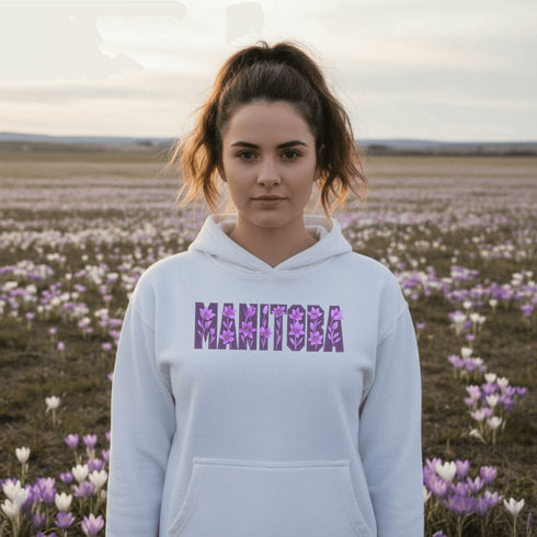 Celebrate the beauty of the prairies with our Manitoba Hoodie, featuring bold lettering filled with delicate purple prairie crocus flowers.