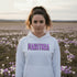 Celebrate the beauty of the prairies with our Manitoba Hoodie, featuring bold lettering filled with delicate purple prairie crocus flowers.