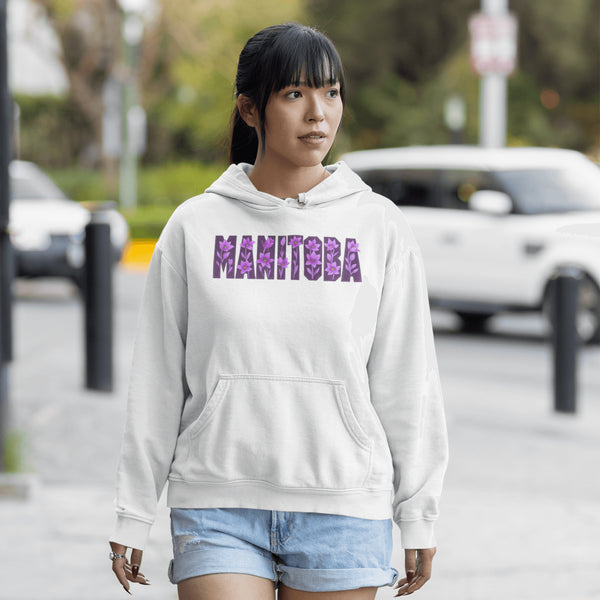 Celebrate the beauty of the prairies with our Manitoba Hoodie, featuring bold lettering filled with delicate purple prairie crocus flowers.