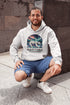Featuring a majestic polar bear set against the breathtaking backdrop of the northern lights, this hoodie celebrates the spirit of Manitoba’s wild landscapes.