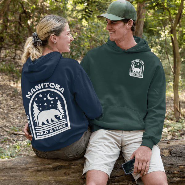 This cozy hoodie features a bold back print of a bear walking beneath a crescent moon and pine trees—capturing everything we love about Canada’s wilderness.