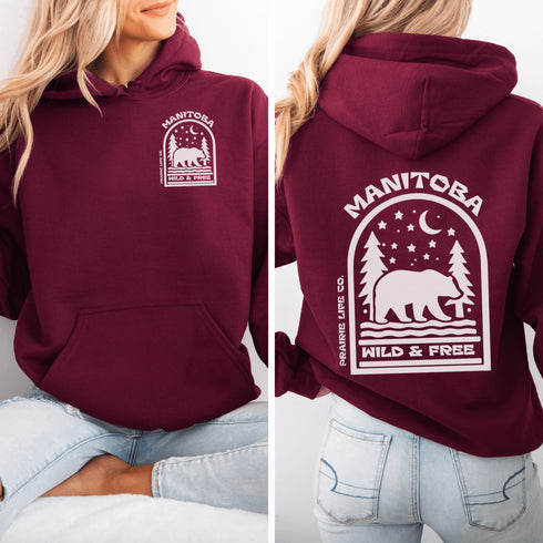 This cozy hoodie features a bold back print of a bear walking beneath a crescent moon and pine trees—capturing everything we love about Canada’s wilderness.
