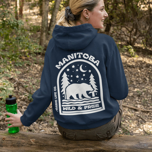 This cozy hoodie features a bold back print of a bear walking beneath a crescent moon and pine trees—capturing everything we love about Canada’s wilderness.