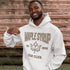 Woman wearing beige Maple Syrup Fan Club hoodie with maple leaf graphic, smiling outdoors in a natural setting with trees in the background