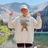 Funny Sasquatch fishing graphic printed on a unisex hoodie featuring a vintage Bigfoot fisherman design, shown on multiple hoodie colors and lifestyle mockups perfect for outdoor and fishing apparel.