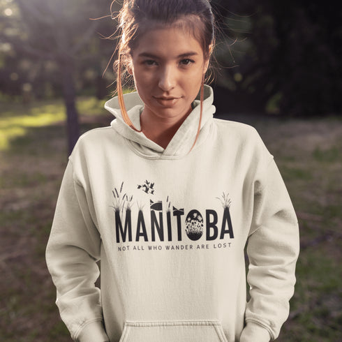 Featuring a serene prairie landscape, the design captures the essence of the heartland with wildflowers and prairie grasses growing out of the letters Manitoba.