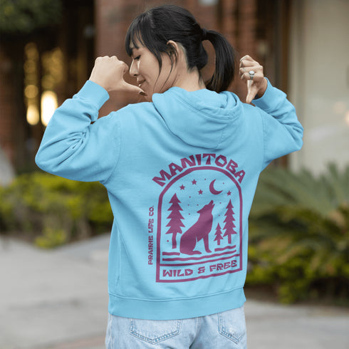 Featuring a howling wolf surrounded by pine trees, twinkling stars, and a crescent moon, this hoodie captures the magic of the northern wilderness.