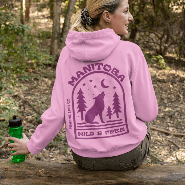 Featuring a howling wolf surrounded by pine trees, twinkling stars, and a crescent moon, this hoodie captures the magic of the northern wilderness.