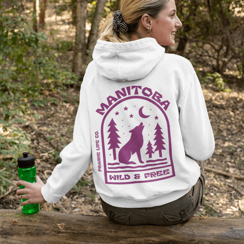 Featuring a howling wolf surrounded by pine trees, twinkling stars, and a crescent moon, this hoodie captures the magic of the northern wilderness.