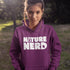 Person wearing a purple hoodie with 'Nature Nerd' text in an outdoor setting