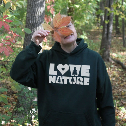 Person wearing a hoodie with 'Love Nature' text in a forest setting