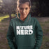 Person wearing a green hoodie with 'Nature Nerd' text in a natural setting