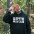 Person wearing a hoodie with 'Love Nature' text in a forest setting