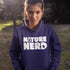 Person wearing a blue hoodie with 'Nature Nerd' text in a natural setting