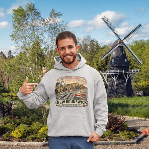 Man wearing a hoodie with a New Brunswick design in front of a windmill.