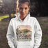 Person wearing a white hoodie with New Brunswick design outdoors