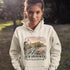 Woman wearing a hoodie with a New Brunswick design outdoors