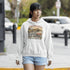 Woman wearing a hoodie with a graphic design on a street.