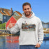 Nova Scotia hoodie with lighthouse coastal fishing village graphic worn by model outdoors near ocean cliffs