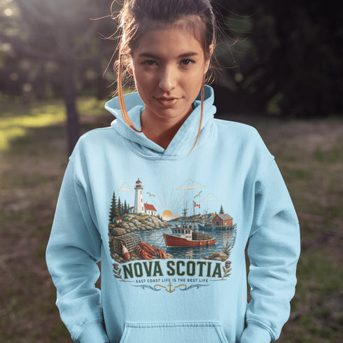 Nova Scotia hoodie with lighthouse coastal fishing village graphic worn by model outdoors near ocean cliffs
