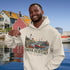 Nova Scotia hoodie with lighthouse coastal fishing village graphic worn by model outdoors near ocean cliffs