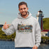 Nova Scotia hoodie with lighthouse coastal fishing village graphic worn by model outdoors near ocean cliffs