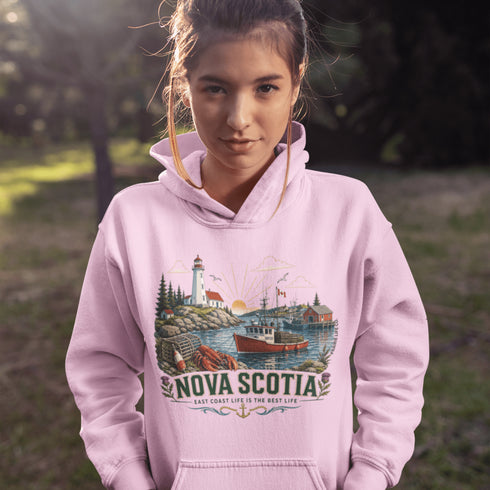 Nova Scotia hoodie with lighthouse coastal fishing village graphic worn by model outdoors near ocean cliffs
