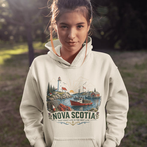 Nova Scotia hoodie with lighthouse coastal fishing village graphic worn by model outdoors near ocean cliffs