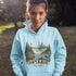 Person wearing a light blue hoodie with Ontario-themed design outdoors