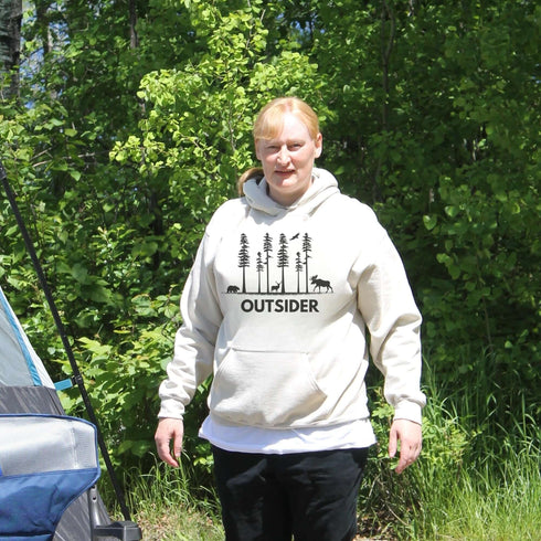 The Outsider Hoodie features a charming forest scene with a moose, a bear, and a deer—aka the unspoken rulers of the woods.