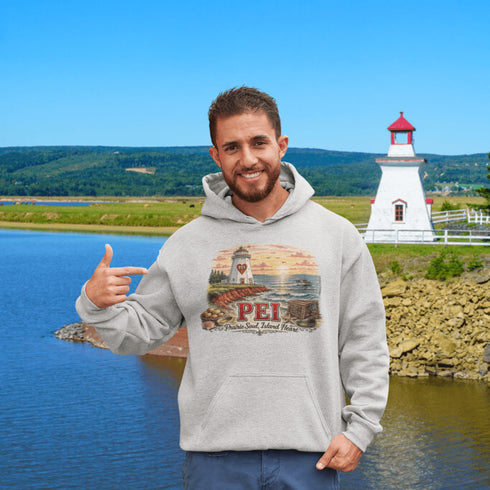 Man wearing a hoodie with a lighthouse design in front of a scenic lake and lighthouse.