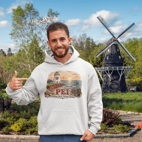 Man wearing a hoodie with a scenic design in front of a windmill and trees