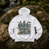 A white pullover hoodie laid flat on a mossy rock outdoors, showing the back graphic with trees, butterflies, a fox, and the text 'PROTECT OUR WILDFIFE' and 'LEARN BEFORE YOU BURN.' A tan cap, backpack, and water bottle are placed around it in a natural outdoor setting.
