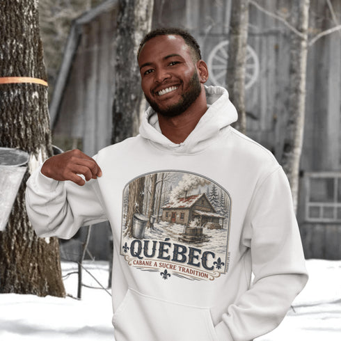 Man wearing a white hoodie with a Québec-themed design in a snowy outdoor setting.