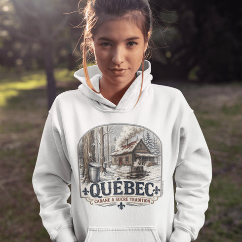 Person wearing a white hoodie with a Québec-themed design outdoors.