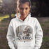 Person wearing a white hoodie with a Québec-themed design outdoors.