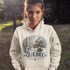 Person wearing a hoodie with a Québec-themed design outdoors.