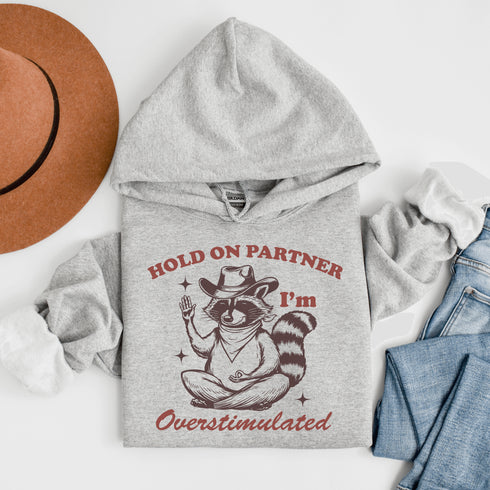 This hoodie combines the wisdom of the Wild West with the zen of overstimulation recovery. Featuring a raccoon—rocking a cowboy hat, and meditating.