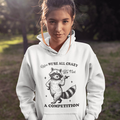Meet your new spirit animal: a sassy raccoon with zero chill and a motto to live by: "Relax, we're all crazy—it’s not a competition."