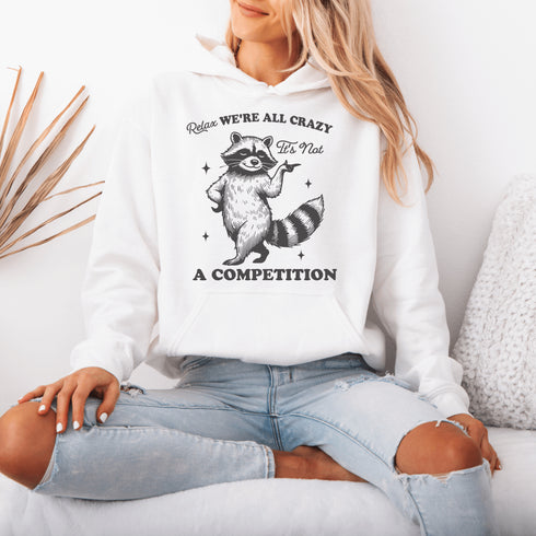 Meet your new spirit animal: a sassy raccoon with zero chill and a motto to live by: "Relax, we're all crazy—it’s not a competition."