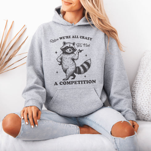 Meet your new spirit animal: a sassy raccoon with zero chill and a motto to live by: "Relax, we're all crazy—it’s not a competition."