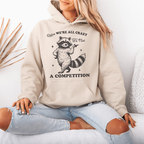 Meet your new spirit animal: a sassy raccoon with zero chill and a motto to live by: "Relax, we're all crazy—it’s not a competition."