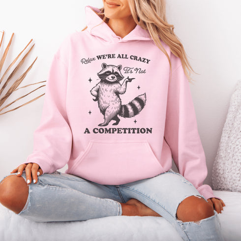 Meet your new spirit animal: a sassy raccoon with zero chill and a motto to live by: "Relax, we're all crazy—it’s not a competition."