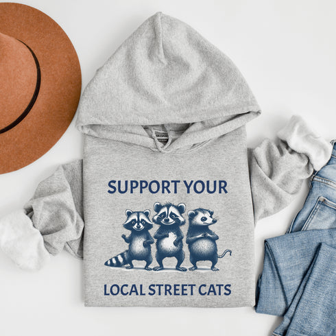 Nothing says “community support” like two raccoons and a possum banding together for the greater good (or maybe just snacks).