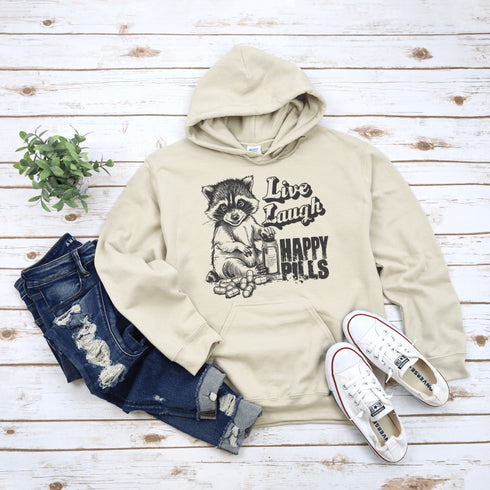 Introducing the "Live, Laugh, Happy Pills" Hoodie—because who better to take life advice from than a raccoon with a bottle of questionable pharmaceuticals? 🦝💊
